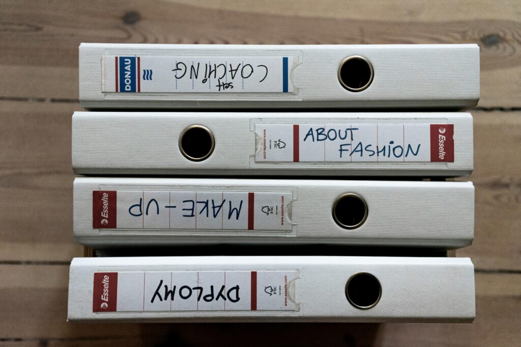 pexels photo 4502976 4502976 From above of collection of ring binders with stickers and written titles on wooden parquet